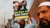 FILE - A supporter of Islamic charity organization Jamaat-ud-Dawa (JuD), carries a sign with others as they listen the speech of leaders (unseen) to condemn the house arrest of Hafiz Muhammad Saeed, chief of (JuD), during a protest demonstration in Karachi, Pakistan, Feb. 3, 2017.