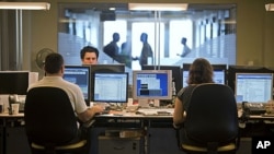 Brokers look at screens in the trading room of an investment bank in Tel Aviv, August 7, 2011