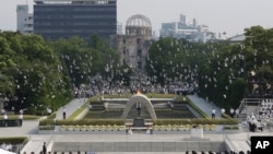 FILE - In this Aug. 6, 2013 file photo, doves fly over the cenotaph dedicated to the victims of the atomic bombing at the Hiroshima Peace Memorial Park during a ceremony marking the 68th anniversary of the bombing, in Hiroshima, western Japan.