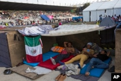 Central American migrants rest at the Jesus Martinez stadium in Mexico City, Nov. 6, 2018. Humanitarian aid converged around the stadium in Mexico City where thousands of Central American migrants winding their way toward the United States were resting Tuesday after an arduous trek that has taken them through three countries in three weeks.