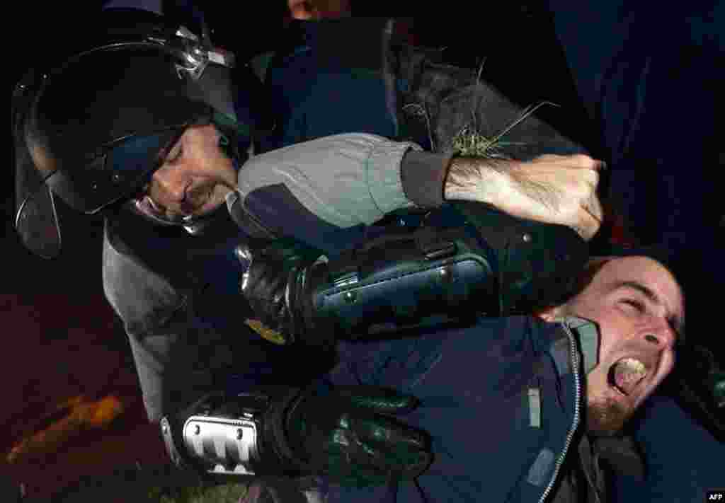 A picketer scuffles with Spanish riot police officer in Madrid, March 29, 2012. (Reuters)