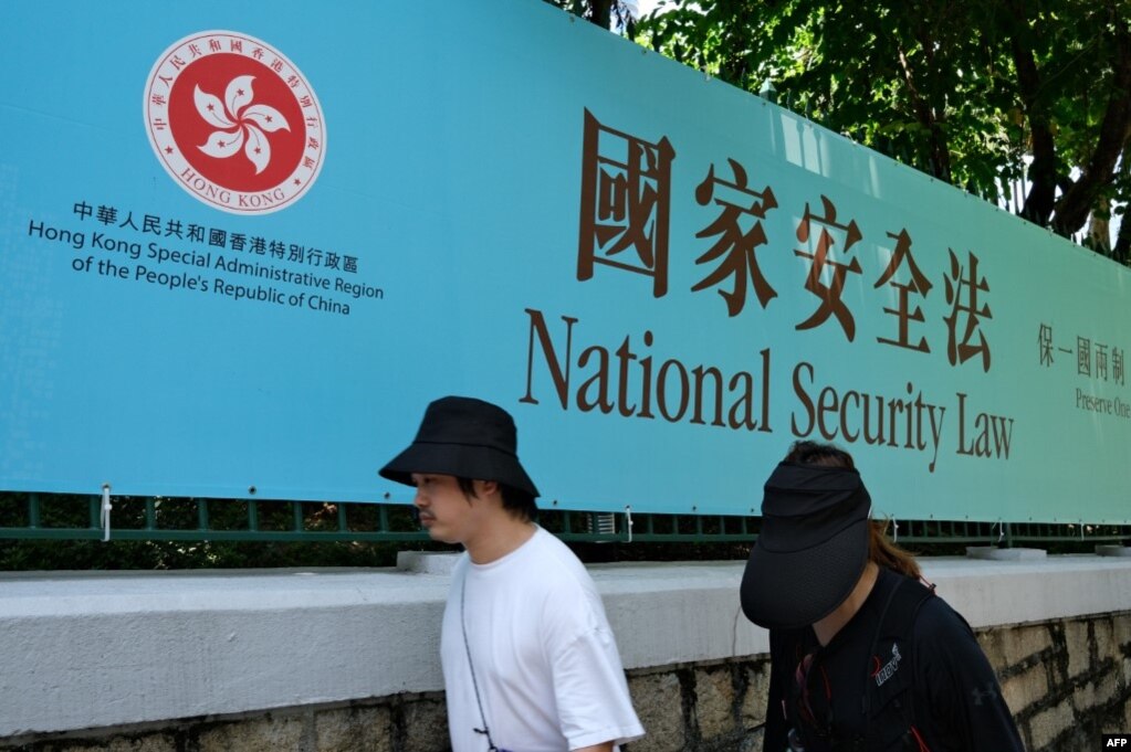 行人走过香港街头港版国安法的宣传牌。（2020年7月15日）(photo:VOA)