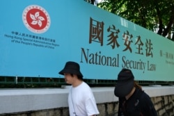 行人走過香港街頭港版國安法的宣傳牌。（2020年7月15日）