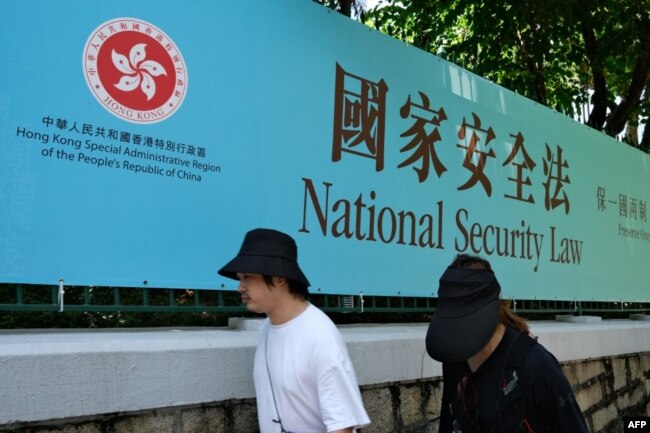 行人走过香港街头港版国安法的宣传牌。（2020年7月15日）