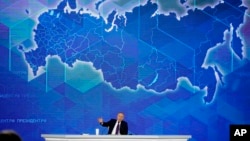 Russian President Vladimir Putin gestures while speaking during his annual news conference in Moscow, Russia, Dec. 23, 2021. 