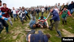 Players fight for the bottle during the bottle-kicking game in Hallaton, central England, April 1, 2013.