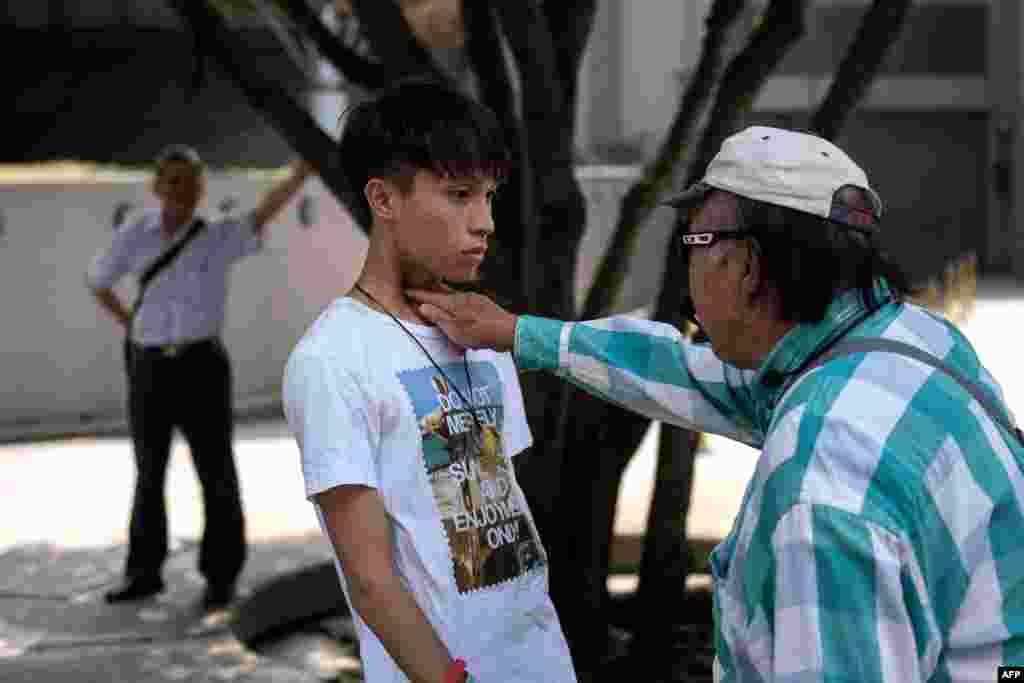A man jabs his fingers in the throat of a pro-democracy protester in the Central district of Hong Kong.