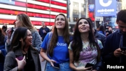 Employees of Coinbase Global Inc, the biggest U.S. cryptocurrency exchange, watch as their listing is displayed on the Nasdaq MarketSite jumbotron at Times Square in New York, U.S., April 14, 2021. REUTERS/Shannon Stapleton