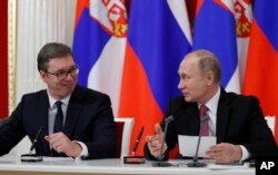 FILE - Russian President Vladimir Putin (R) and Serbian President Aleksandar Vucic talk to each other during a meeting with the media following their talks in the Kremlin in Moscow, Russia, Dec. 19, 2017.