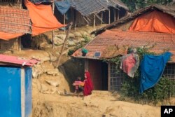 FILE - A Rohingya Muslim refugee sits with her child outside their shelter at Balukhali refugee camp near Cox's Bazar, in Bangladesh, Nov. 17, 2018.