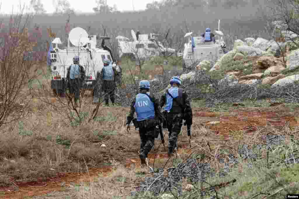 United Nations Interim Force in Lebanon (UNIFIL) troops inspect the remains of a shell that was launched from Lebanon to Israel, Sarada, Lebanon, Dec. 29, 2013.