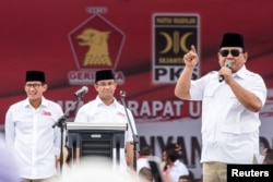 FILE - Gerindra party Chairman Prabowo Subianto, right, talks to supporters during a campaign for Anies Baswedan, center, a candidate in the running to lead the Indonesian capital, Jakarta, in Jakarta, Indonesia Feb. 5, 2017.