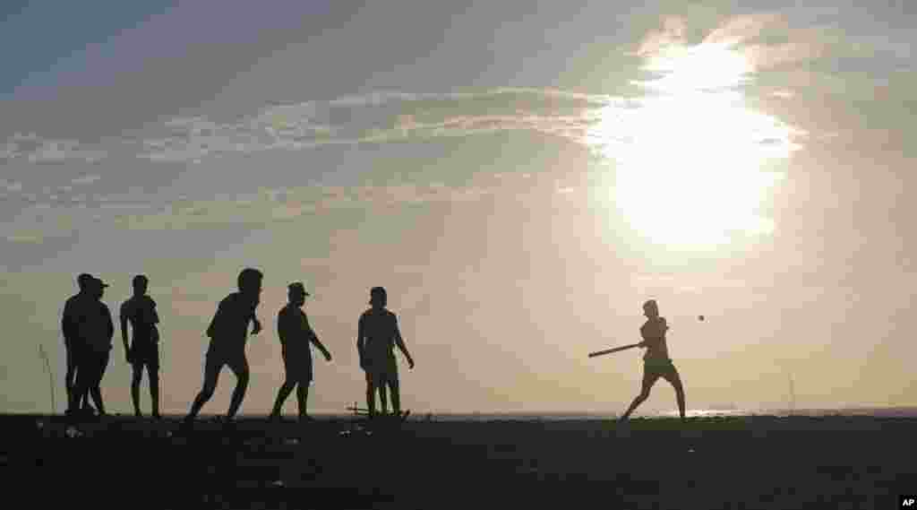 Sri Lankan youths play a pick up game of &quot;Elle&quot;, a local game similar to base ball, on the sea promenade in Colombo.