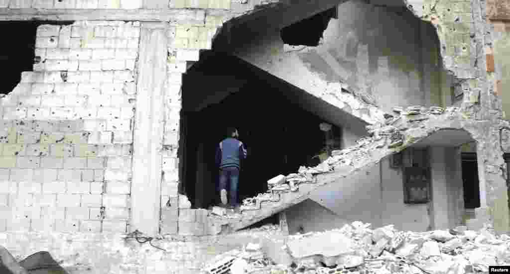 A man is seen on a damaged staircase in Homs, Syria.