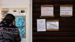 Un hombre con una máscara sanitaria compra cigarrillos en un dispensador, cerca de una tienda de tabaco en Codogno, Italia, una de las ciudades cerradas debido al coronavirus. Foto: Marzio Toniolo. Marzo 1, 2020.
