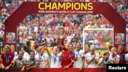 United States goalkeeper Hope Solo (1) hoists the FIFA Women's World Cup trophy as she and her teammates pose with their medals after defeating Japan in the final of the FIFA 2015 Women's World Cup at BC Place Stadium, July 5, 2015.