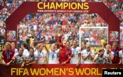 United States goalkeeper Hope Solo (1) hoists the FIFA Women's World Cup trophy as she and her teammates pose with their medals after defeating Japan in the final of the FIFA 2015 Women's World Cup at BC Place Stadium, July 5, 2015.