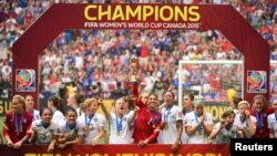 United States goalkeeper Hope Solo (1) hoists the FIFA Women's World Cup trophy as she and her teammates pose with their medals after defeating Japan in the final of the FIFA 2015 Women's World Cup at BC Place Stadium, July 5, 2015.