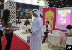 An exhibitor talks to a visitor during the opening day of The World Halal Travel Summit & Exhibition in Abu Dhabi, United Arab Emirates, October 19, 2015.