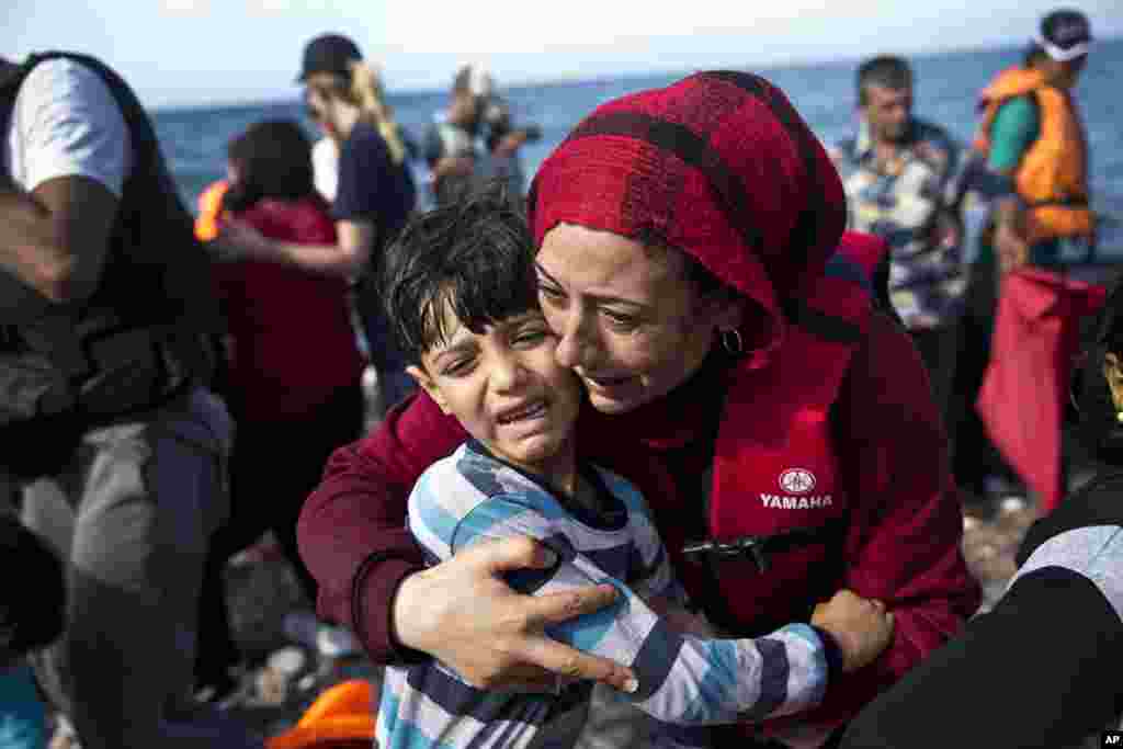 Seorang perempuan Suriah memeluk anaknya saat tiba di pulau Lesbos, Yunani, dengan kapal dari Turki.