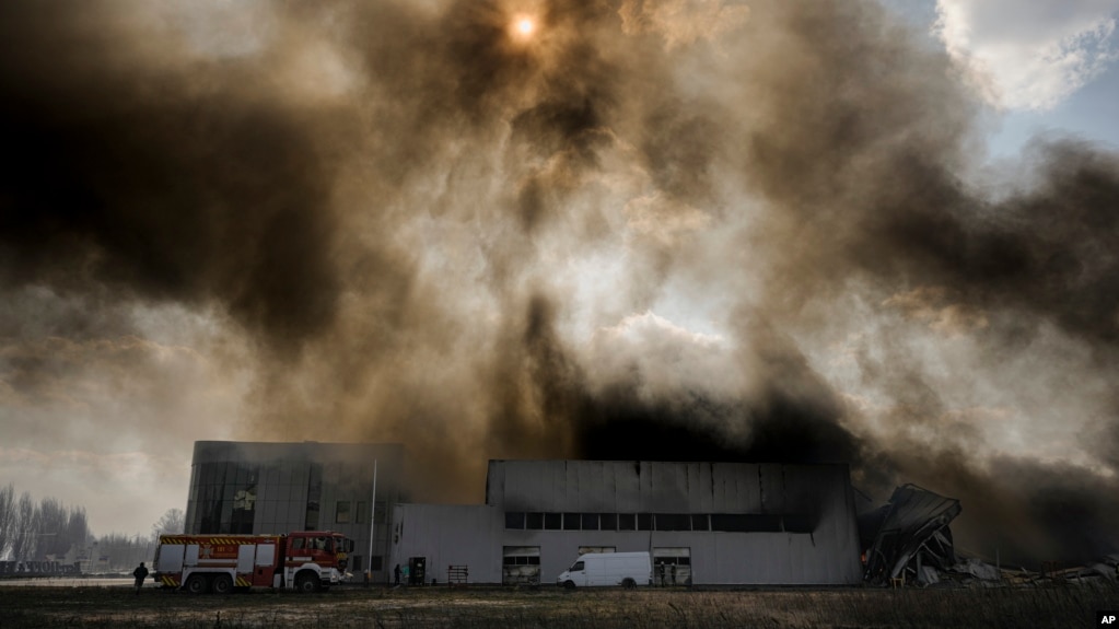 Un denso humo sale de un almacén destruido después de un bombardeo ruso en las afueras de Kiev, Ucrania, el jueves 24 de marzo de 2022.