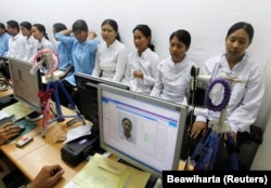 Para pekerja migran tujuan negara-negara Timur Tengah difoto untuk pembuatan paspor di kantor imigrasi Tangerang, Banten, 23 Juni 2011. (Foto: REUTERS/Beawiharta)