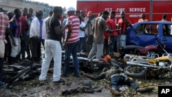 People gather at the site of a blast at the Nyanya Motor Park, about 16 kilometers (10 miles) from the center of Abuja, Nigeria, April 14, 2014.