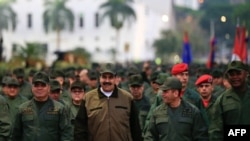 
Esta fotografía publicada por la oficina de prensa del Palacio de Miraflores muestra al presidente de Venezuela, Nicolás Maduro (D) agitando tropas militares acompañado por el Ministro de Defensa Vladimir Padrino (I) en el "Fuerte Tiuna" en Caracas, Venezuela. 