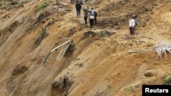 Residents walk along a path in an area affected by a landslide after an earthquake struck in Koto Timur district in Padang Pariaman, a port city sits atop one of the world's most active seismic fault lines along the Pacific ‘Ring of Fire’, October 3, 2009