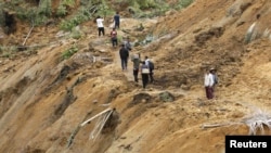 Warga di Koto Timur, Padang Pariaman, Sumatera Barat memeriksa lokasi tanah longsor akibat gempa bumi (foto: 3 Oktober 2009). 