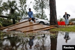 Joseph Howat remueve una cerca dañada por el huracán Michael en su negocio en Panama City Beach, Florida, el 10 de octubre de 2018.