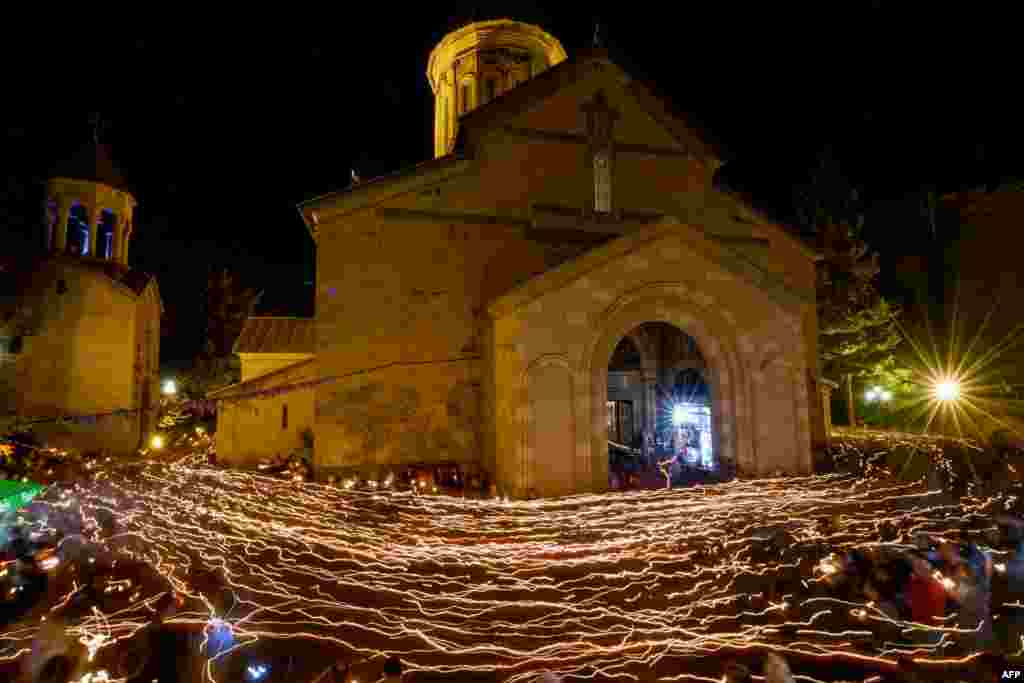 Worshipers walk around the Sioni Cathedral holding lit candles during a midnight Easter service in Tbilisi, Georgia.