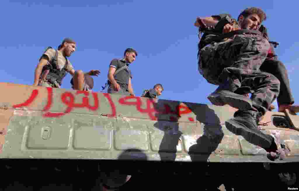 12일 군용차에서 뛰어내리는 알레포 근교 사라키브 지역 반군들. 차에는 &#39;혁명 앞으로&#39; 라고 적혀있다.