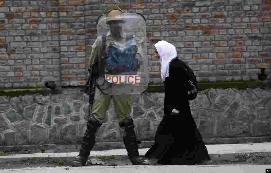 A Kashmiri Muslim student walks past an Indian policeman during a protest against recent cases of rape in the country, in Srinagar, Indian-controlled Kashmir. The rape and murder of an 8-year-old girl in Kashmir and the abduction and rape of a teenage girl in northern Uttar Pradesh state triggered fresh rounds of protests across the country.