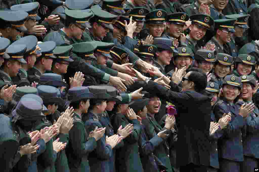 Graduating cadets reach to shake hands with Taiwanese President Ma Ying-jeou during a ceremony marking the 90th anniversary of military academy in Kaohsiung.