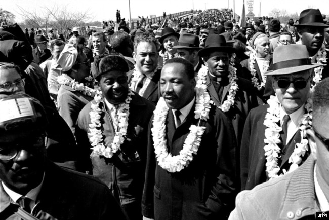 Martin Luther King Jr. cruza el puente Edmund Pettus en Selma, Alabama, en una marcha hacia la capital Montgomery el 21 de marzo de 1965.