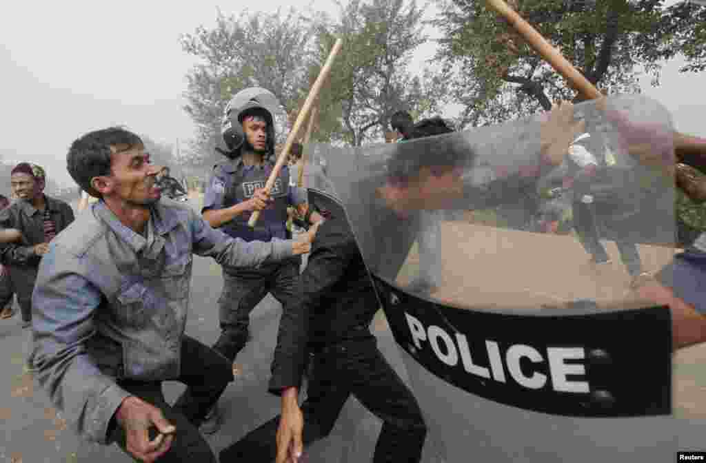 A pro-government activist (L) attacks an activist of the Bangladesh Nationalist Party (BNP), suspected of vandalising a bus, as police try to save him during a nationwide blockade in Kachpur near Dhaka December 9, 2012. Police fired rubber bullets and tea