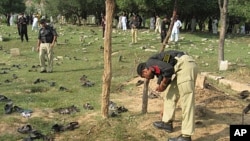 Pakistani police officers collect evidence at the site of a deadly suicide bombing in Shina Samar Bagh in Lower Dir, Pakistan, September 15, 2011.