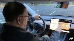 Ông Vince Patton, chủ nhân một chiếc xe Tesla mới trình bày cách chơi trò chơi video trên xe.
