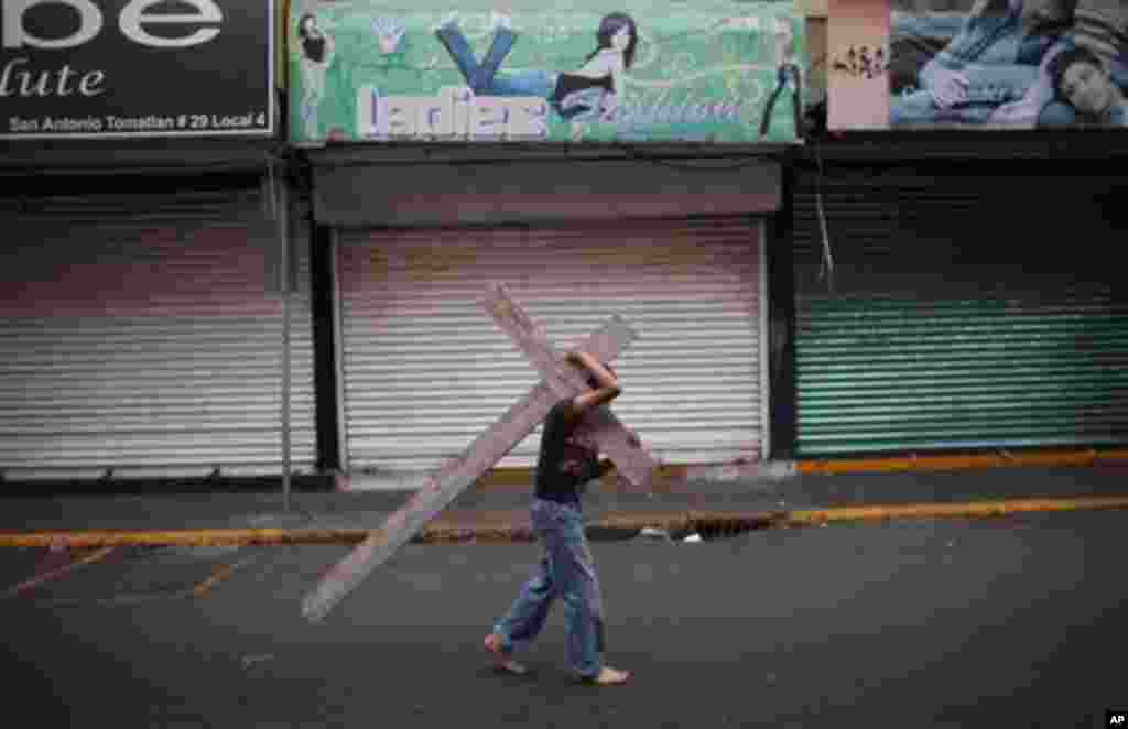 A boy carries a cross as he takes part in a procession during Holy Week in Mexico City, Friday, April 6, 2012. Holy Week commemorates the last week of the life of Jesus, culminating in his crucifixion on Good Friday and his resurrection on Easter Sunday.