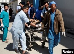 Men transport a victim to a hospital after a blast in Kabul, Afghanistan, March 21, 2018.