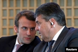 FILE - French Economy Minister Emmanuel Macron (L) and Germany's Economy Minister Sigmar Gabriel attend a news conference to present the Franco-German report on economic reforms and investment at the Bercy Finance Ministry in Paris, Nov. 27, 2014.