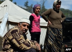 FILE - Syrian Turkmen are seen at a make-shift refugee camp some kilometers away from the Syria-Turkey border, Apr. 23, 2013.