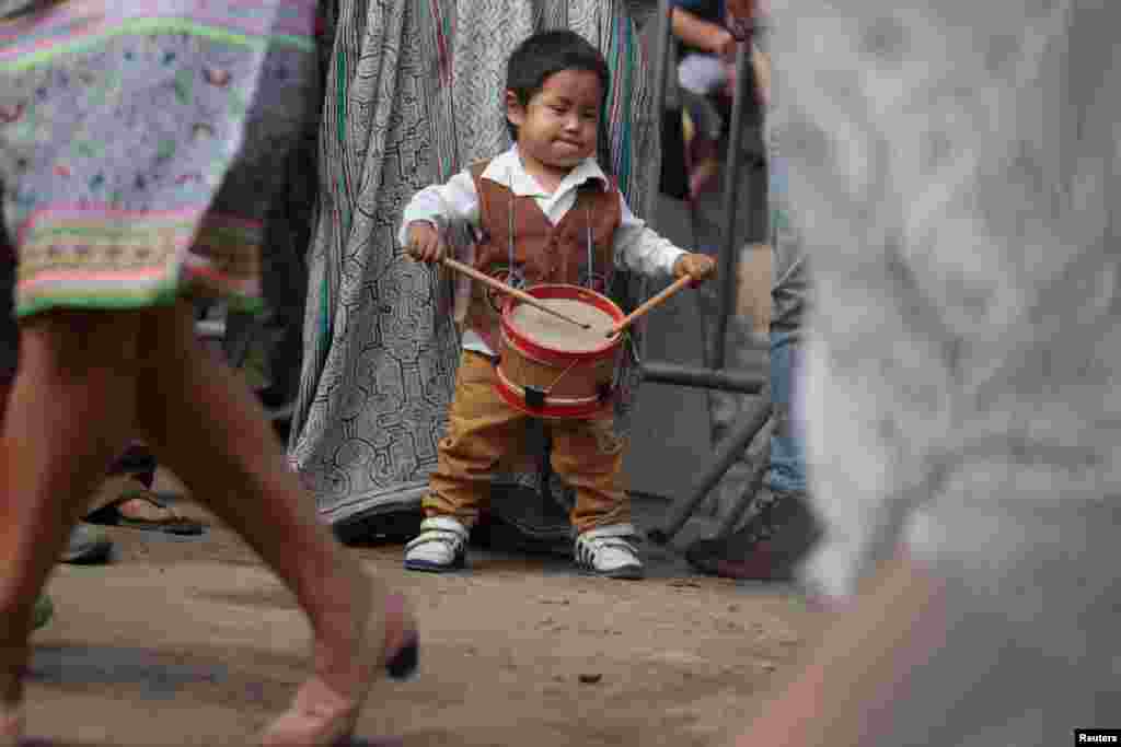 A child member of Cantagallo, an Indigenous Shipibo-Konibo community, plays the drums during a visit of Peru's President Pedro Pablo Kuczynski, in Lima, Peru.