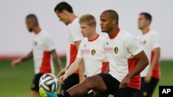 Belgium's captain Vincent Kompany, second right, who is recovering from an injury, keeps a ball up as he takes part in a training session at Estadio Manoel Barradas the day before the World Cup round of 16 soccer match against Belgium, June 30, 2014.