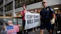 Capitol Hill police officers move in on a group protesting the Republican health care bill outside the offices of Sen. Dean Heller, R-Nev., on Capitol Hill in Washington, July 17, 2017. 