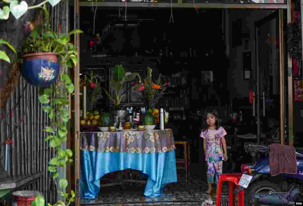 A young girl stands near a table of offerings in celebration of the Khmer New Year in Phnom Penh, Cambodia, April 13, 2020. (Khan Sokummono/VOA Khmer)