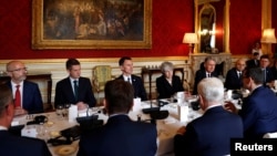 FILE - Britain's Prime Minister Theresa May sits with members of her cabinet at Lancaster House in central London, Britain, Dec. 20, 2018.