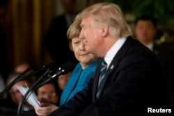 Germany's Chancellor Angela Merkel, left, gives U.S. President Donald Trump a look after he suggested they might have something in common, as he answered a question about his accusation that he had been wiretapped by former President Barack Obama, during their joint news conference in the East Room of the White House in Washington, March 17, 2017.