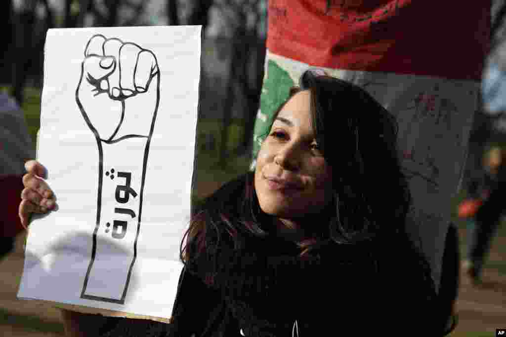 زن جوانی با شعار &laquo;انقلاب&raquo; در حاشیه تجمع لبنانی&zwnj;ها در شهر پاریس برای همراهی با معترضان در بیروت.&nbsp;